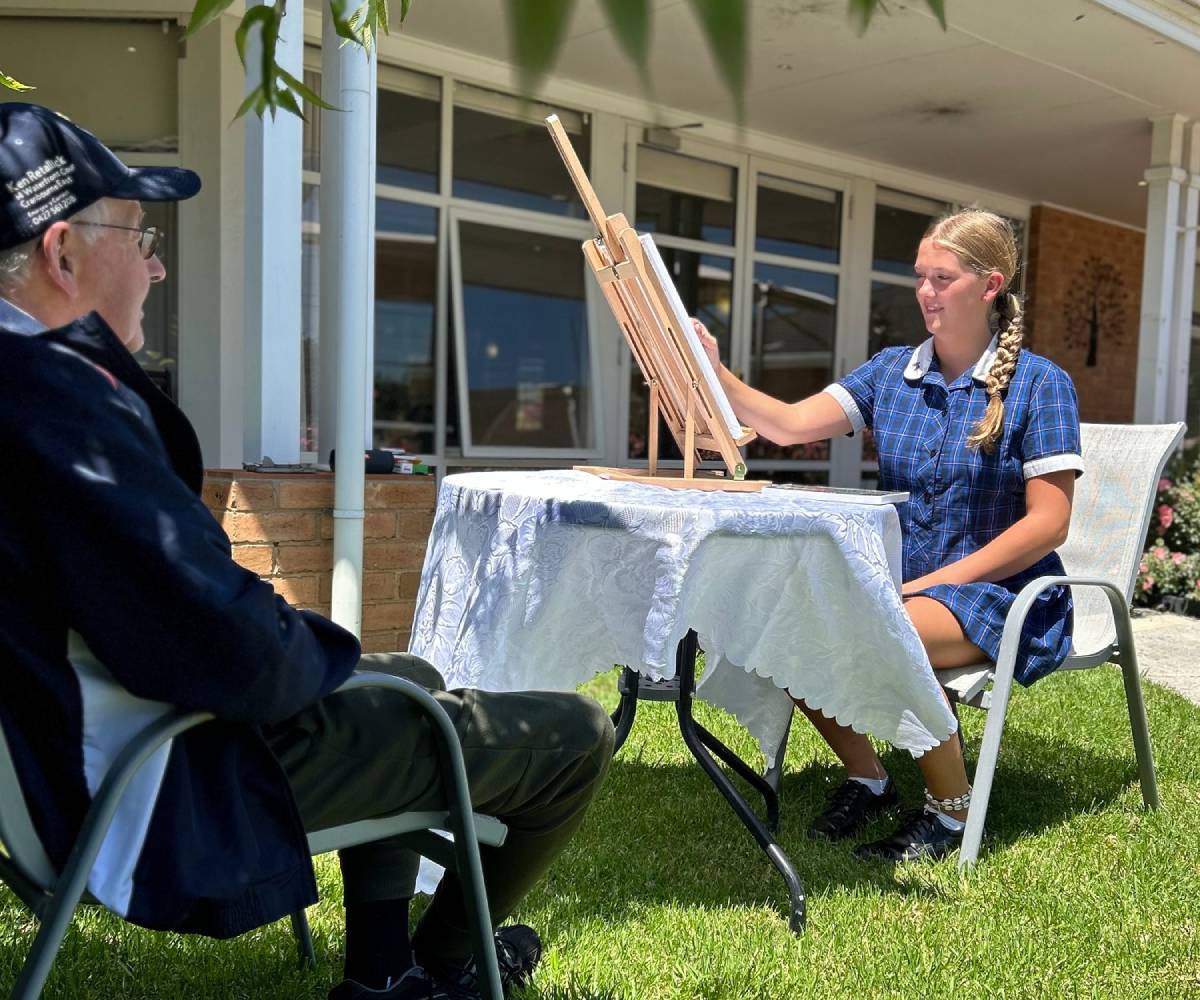 Student Ava painting the portrait of Willow Wood resident Ken.